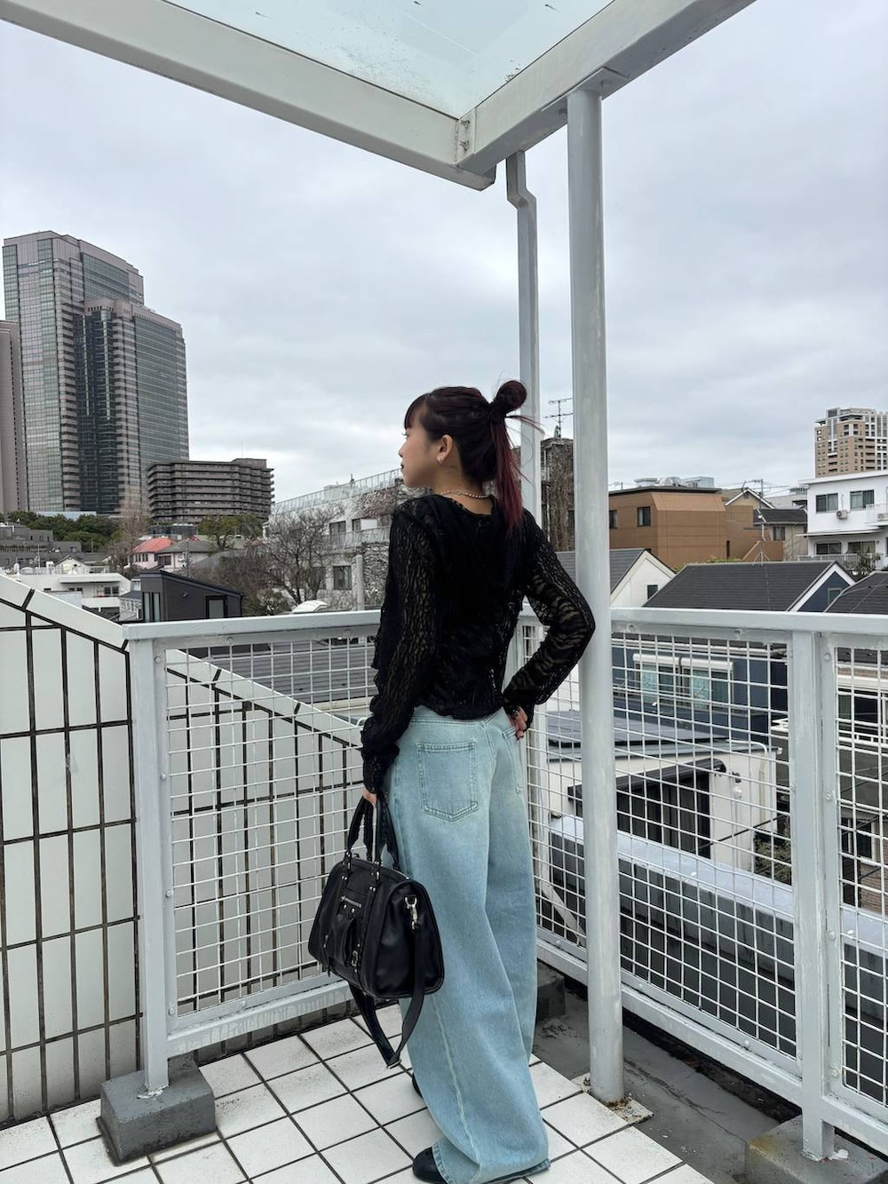 ブラック系のスニーカー、ブラック系のボストンバッグ、ブラック系のパーカーを着用したレディースの春コーディネートの2枚目の写真