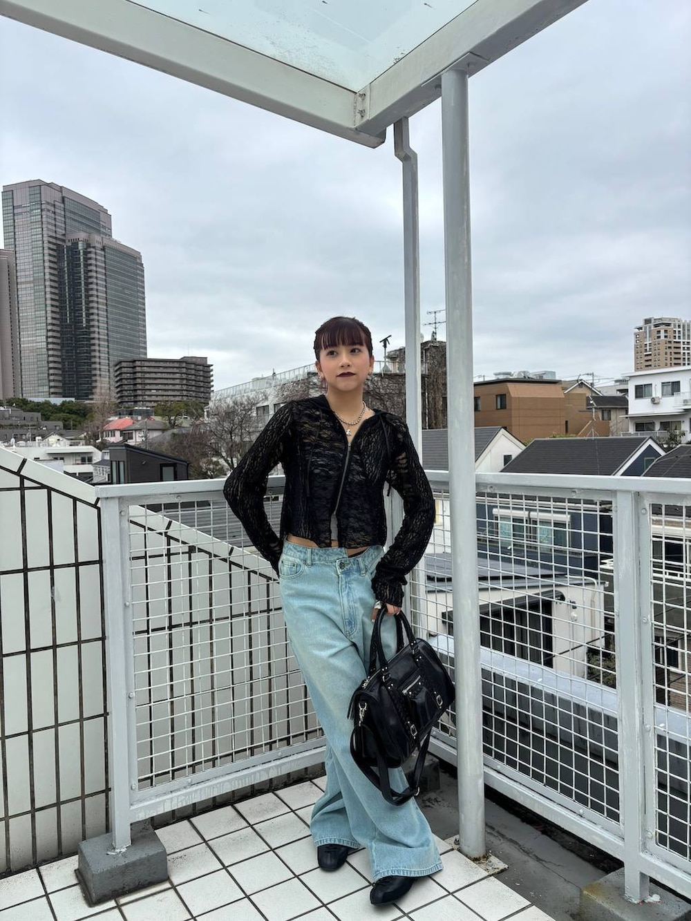 ブラック系のスニーカー、ブラック系のボストンバッグ、ブラック系のパーカーを着用したレディースの春コーディネートの3枚目の写真