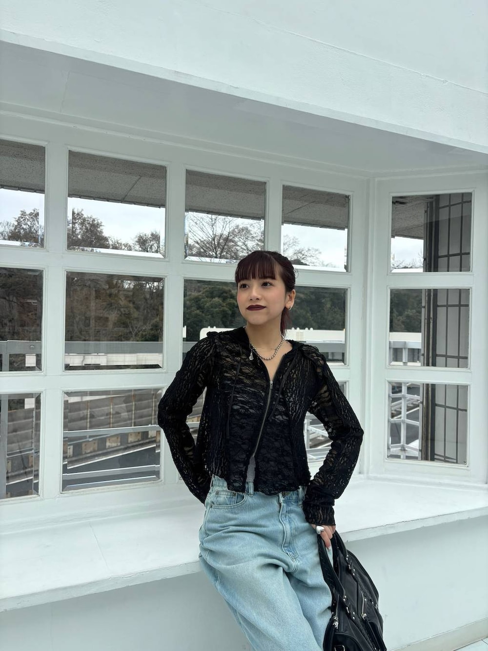 ブラック系のスニーカー、ブラック系のボストンバッグ、ブラック系のパーカーを着用したレディースの春コーディネートの4枚目の写真