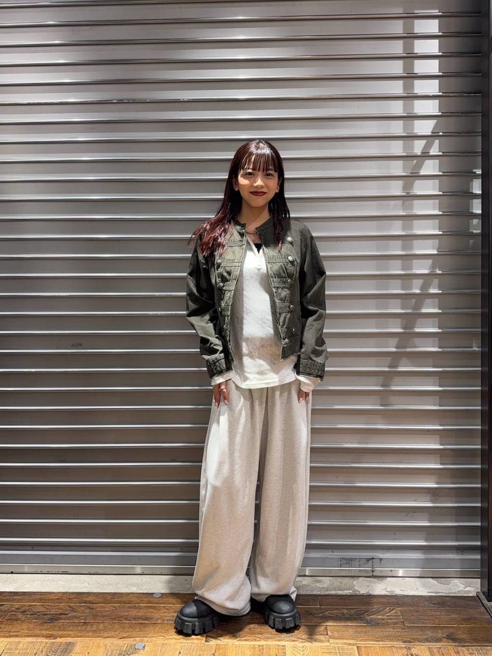 グリーン系のノーカラーコート、ホワイト系のTシャツ/カットソー、ベージュ系のスウェットパンツを着用したレディースの秋コーディネートの3枚目の写真