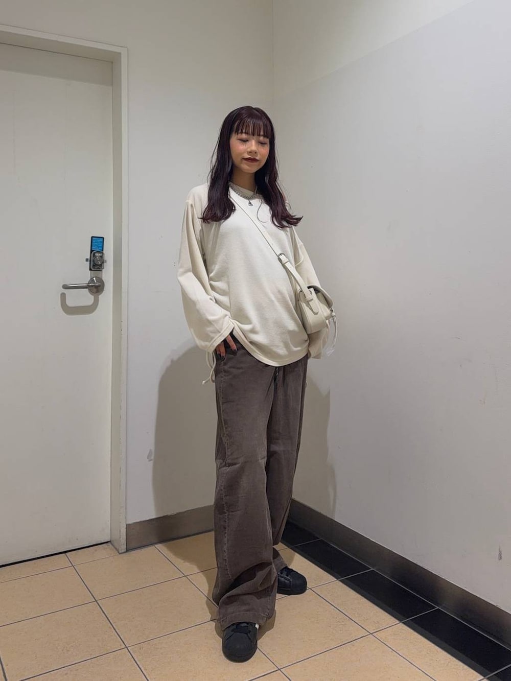 ホワイト系のショルダーバッグ、ブラウン系のその他パンツ、ホワイト系のTシャツ/カットソーを着用したレディースの秋コーディネートの2枚目の写真