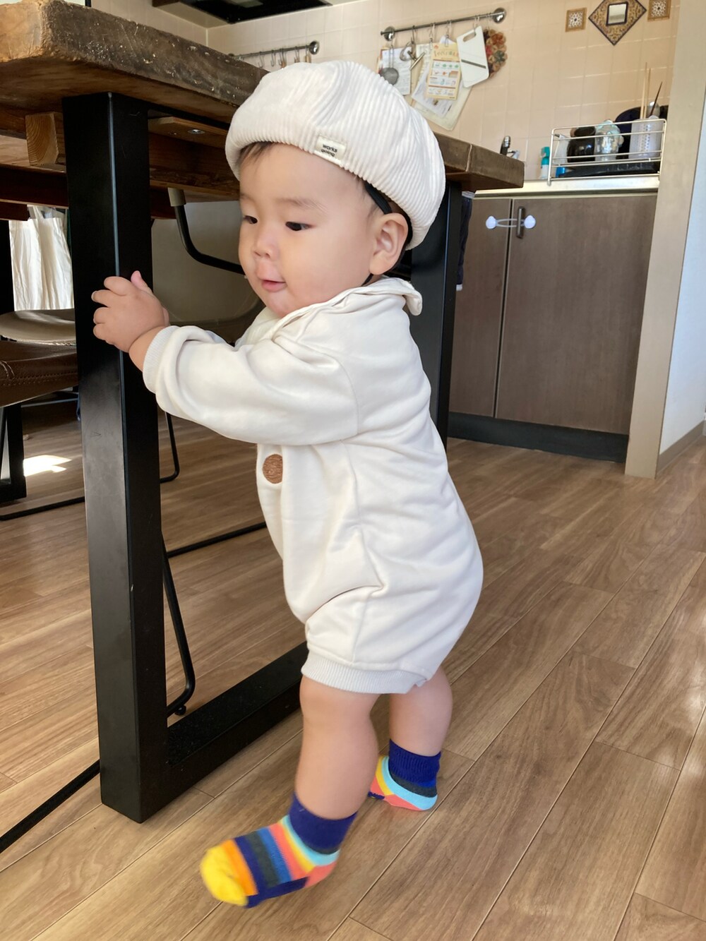 ベージュ系のハンチング/ベレー帽、ベージュ系のスタイ/よだれかけ、ベージュ系のロンパースを着用したキッズの秋コーディネートの2枚目の写真