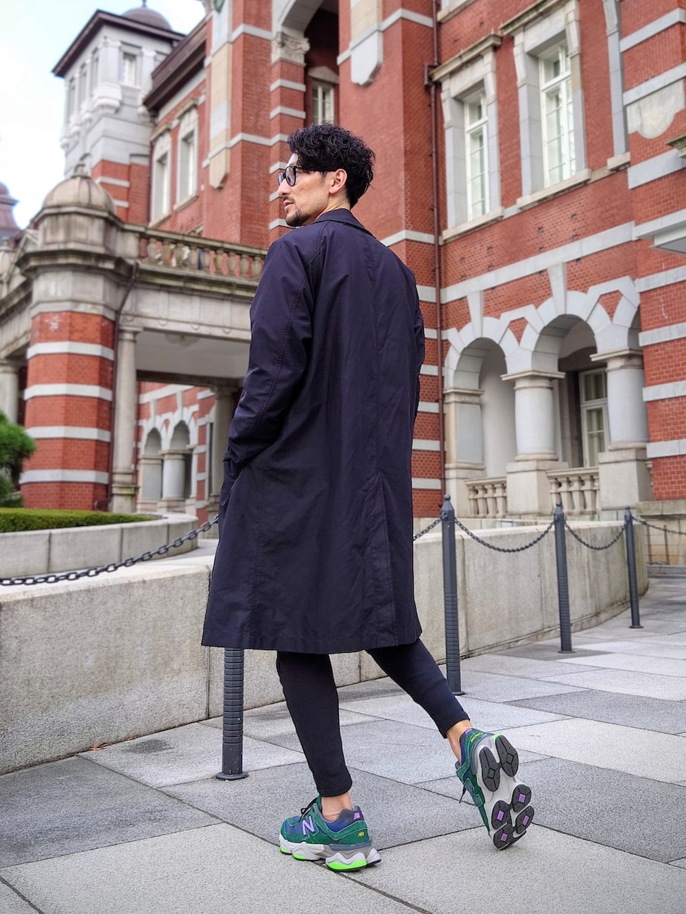 グリーン系のスニーカー、ブラック系のスウェットパンツ、ブラック系のトレンチコートを着用したメンズの冬コーディネートの3枚目の写真