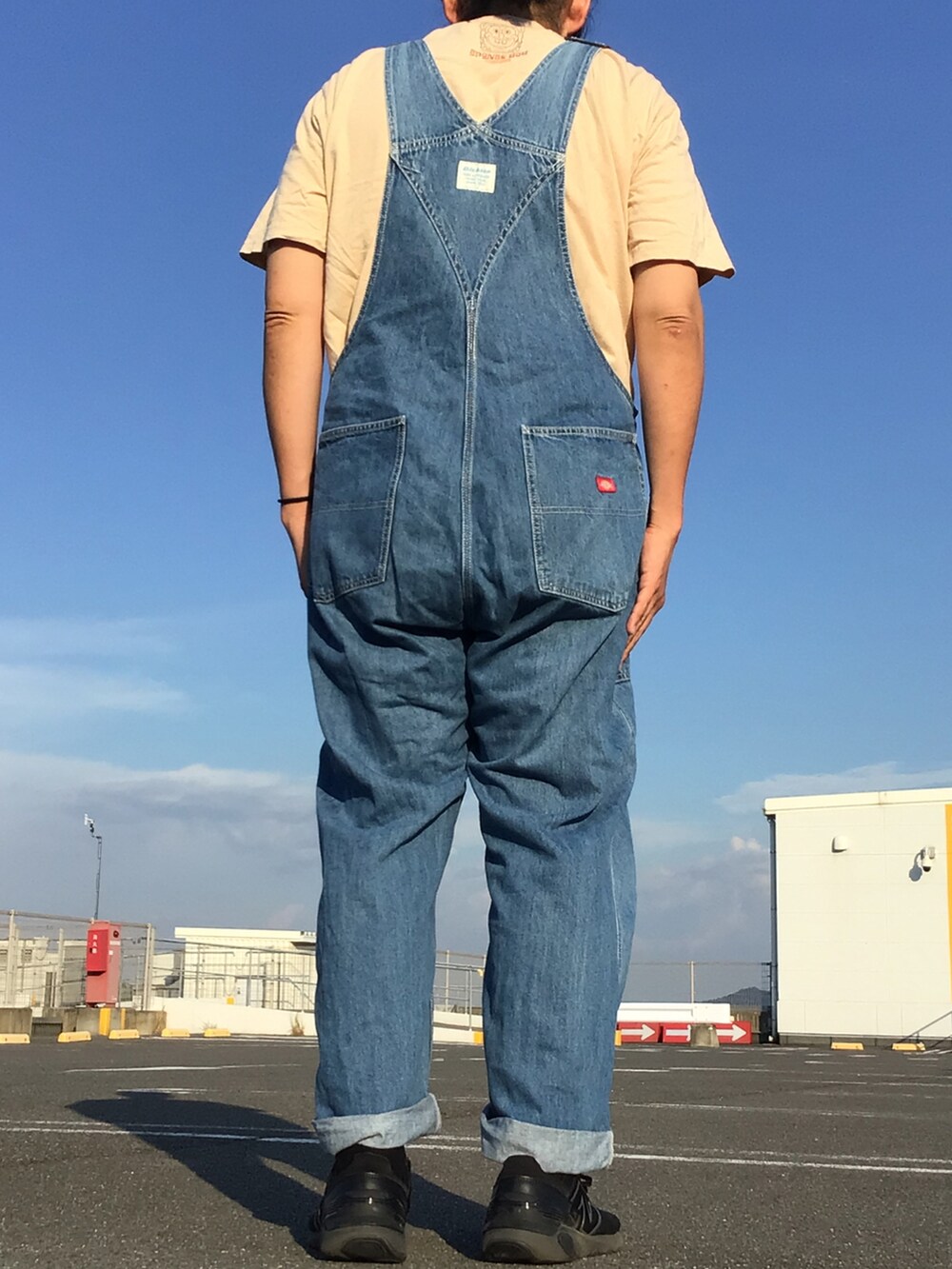 ブルー系のサロペット/オーバーオール、ベージュ系のTシャツ/カットソーを着用したメンズの夏コーディネートの2枚目の写真