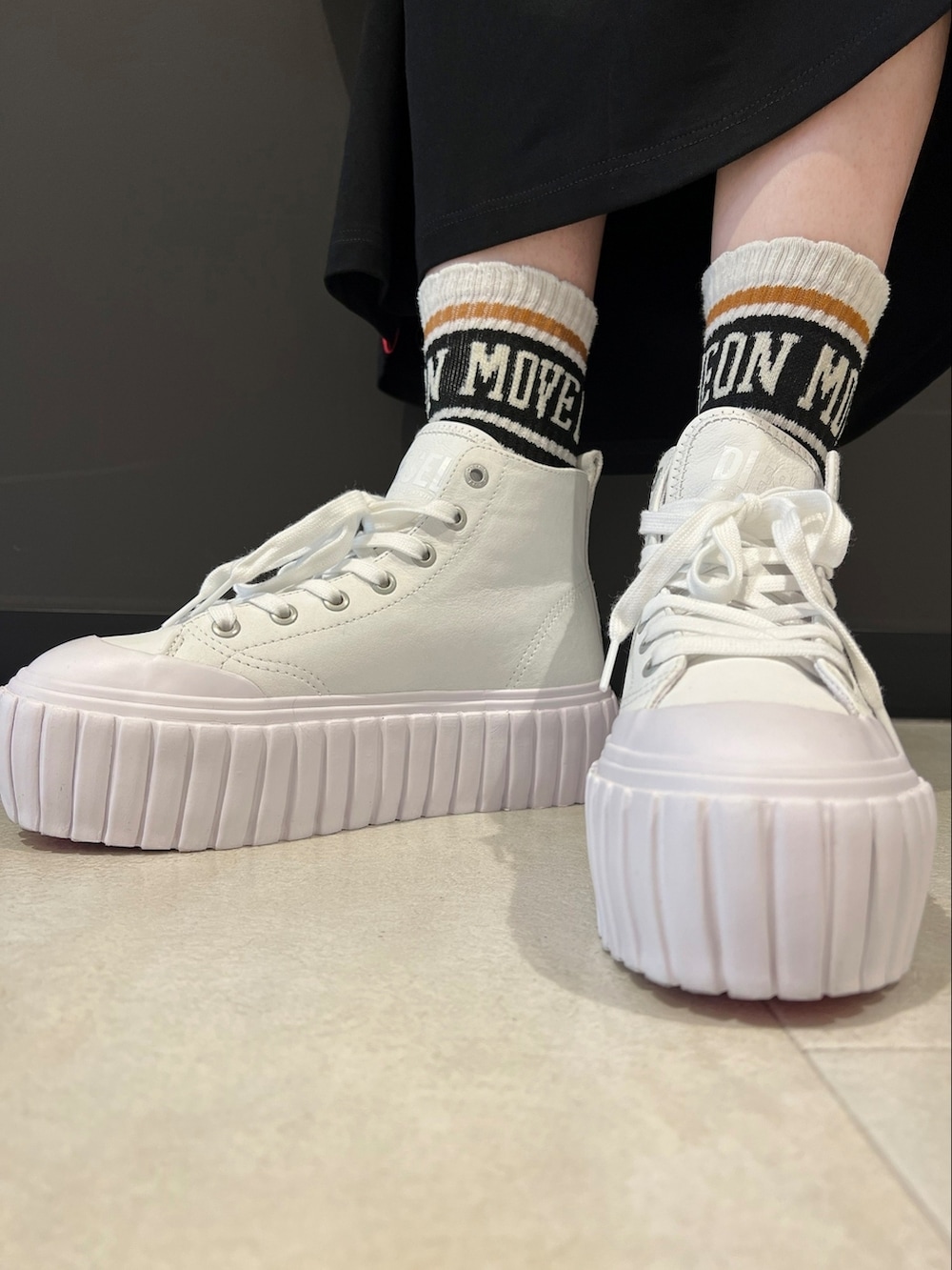 ブラック系のスウェット、ブラック系のワンピース、ホワイト系のショルダーバッグを着用したレディースの春コーディネートの2枚目の写真