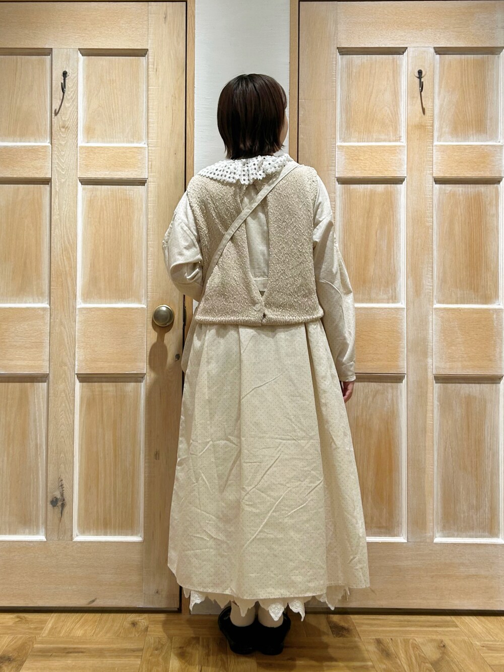 ブラウン系のシャツ/ブラウス、ホワイト系のベスト、ホワイト系のワンピースを着用したレディースの春コーディネートの3枚目の写真