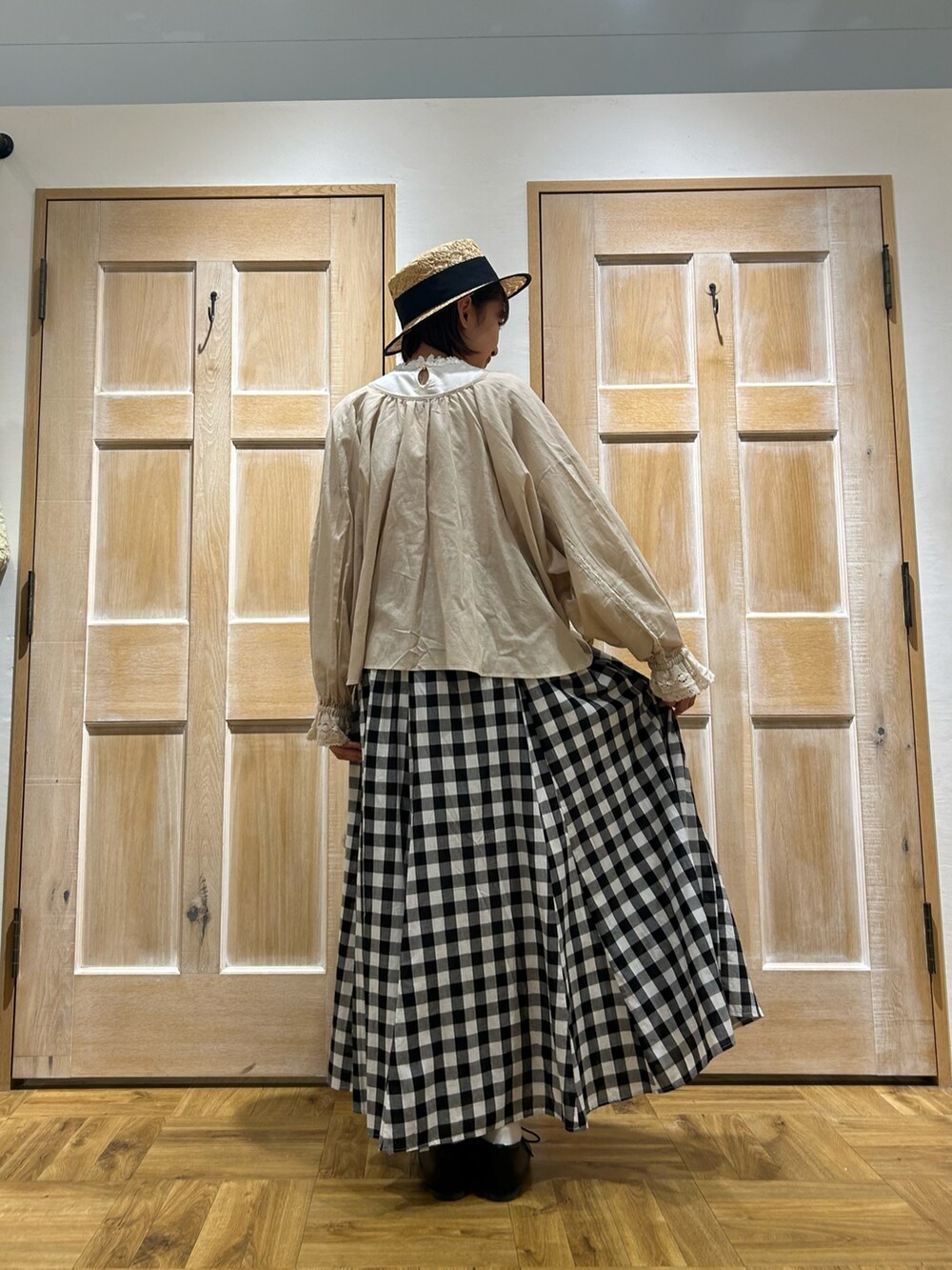 ベージュ系のカーディガン/ボレロ、ホワイト系のTシャツ/カットソー、ブラック系のスカートを着用したレディースの春コーディネートの3枚目の写真