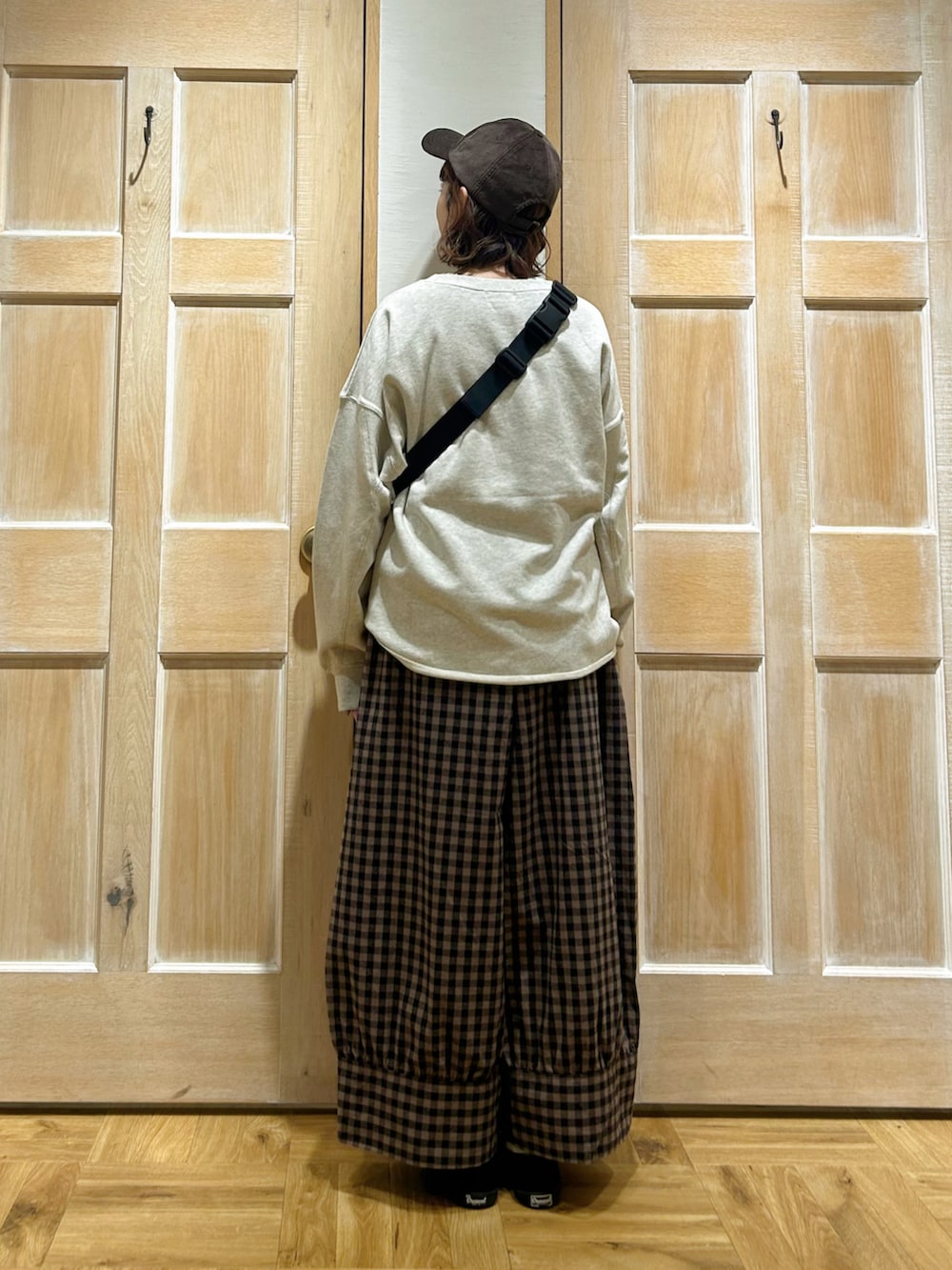 ホワイト系のスウェット、ホワイト系のシャツ/ブラウス、ブラック系のハンドバッグを着用したレディースの秋コーディネートの3枚目の写真