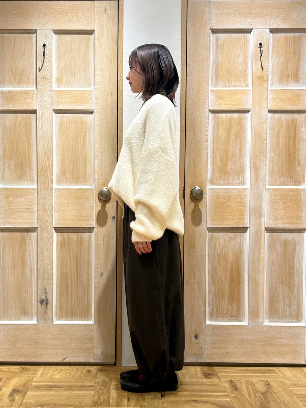 ホワイト系のニット/セーター、ホワイト系のニット/セーター、ブラウン系のその他パンツを着用したレディースの冬コーディネートの2枚目の写真