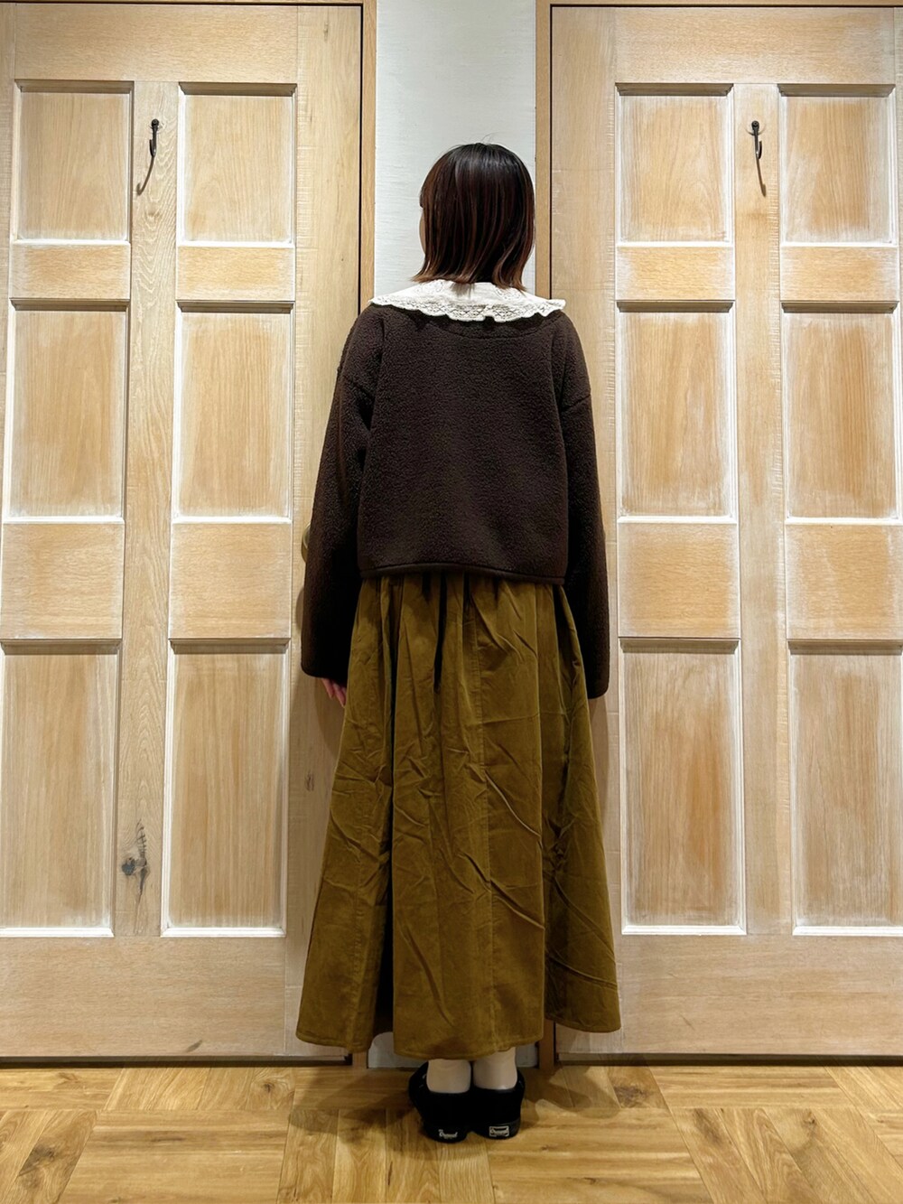 ホワイト系のシャツ/ブラウス、ブラウン系のブルゾン、グリーン系のスカートを着用したレディースの秋コーディネートの3枚目の写真