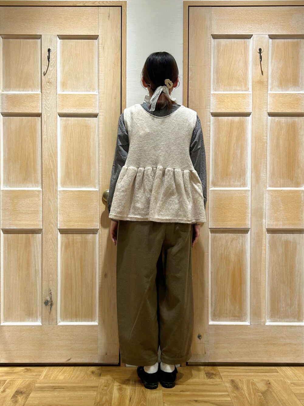 ホワイト系のベスト、ブラック系のシャツ/ブラウス、グリーン系のその他パンツを着用したレディースの冬コーディネートの3枚目の写真