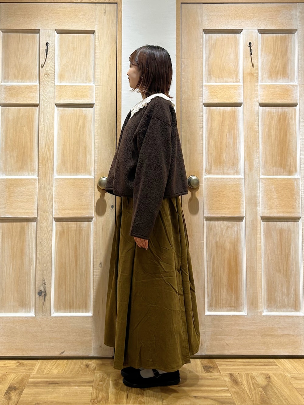 ホワイト系のシャツ/ブラウス、ブラウン系のブルゾン、グリーン系のスカートを着用したレディースの秋コーディネートの2枚目の写真