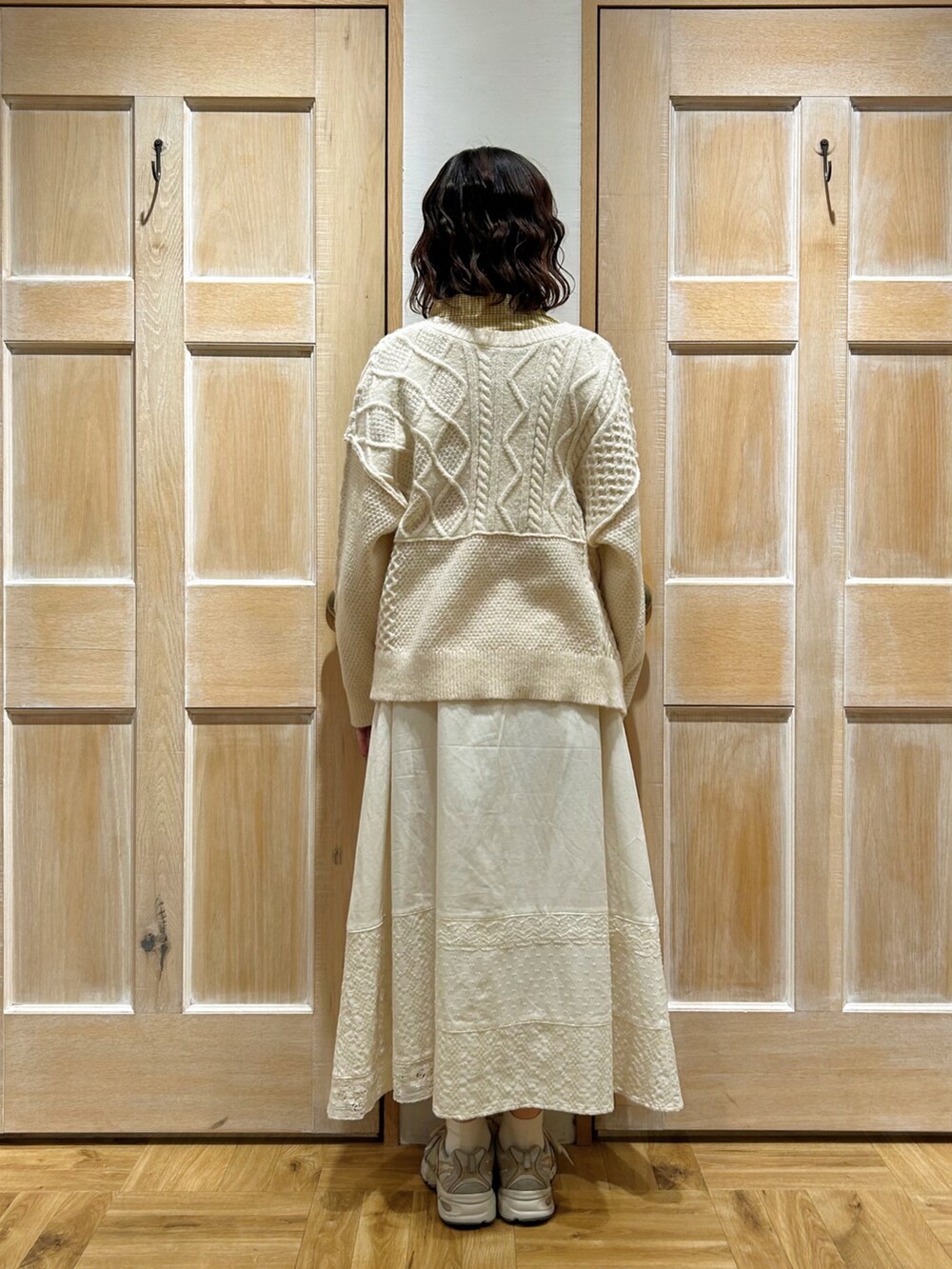 イエロー系のシャツ/ブラウス、ホワイト系のカーディガン/ボレロ、ホワイト系のスカートを着用したレディースの冬コーディネートの3枚目の写真