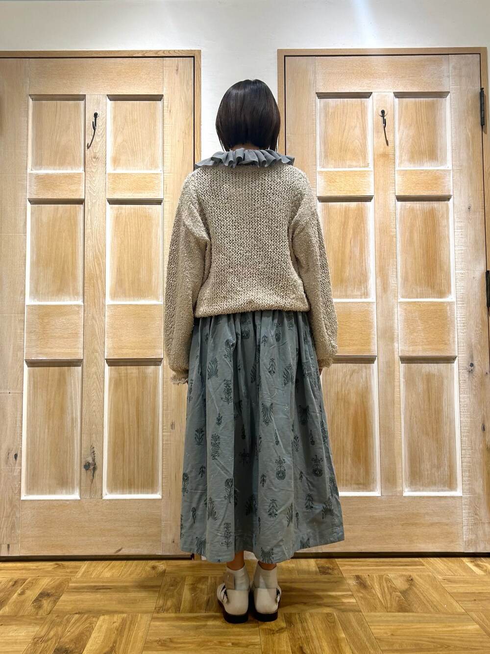 ホワイト系のカーディガン/ボレロ、ブルー系のスカート、ホワイト系のサンダルを着用したレディースの春コーディネートの3枚目の写真