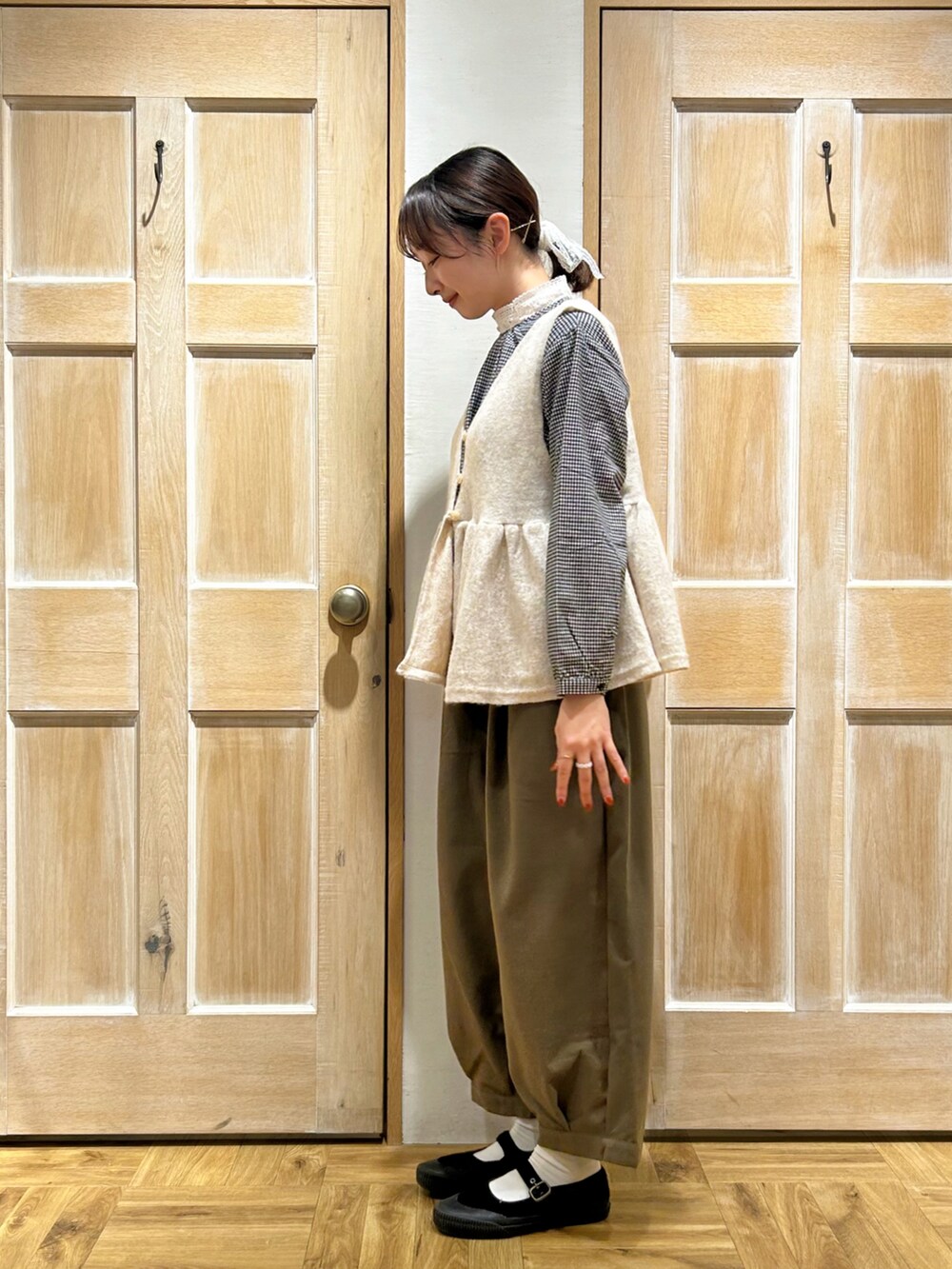 ホワイト系のベスト、ブラック系のシャツ/ブラウス、グリーン系のその他パンツを着用したレディースの冬コーディネートの2枚目の写真