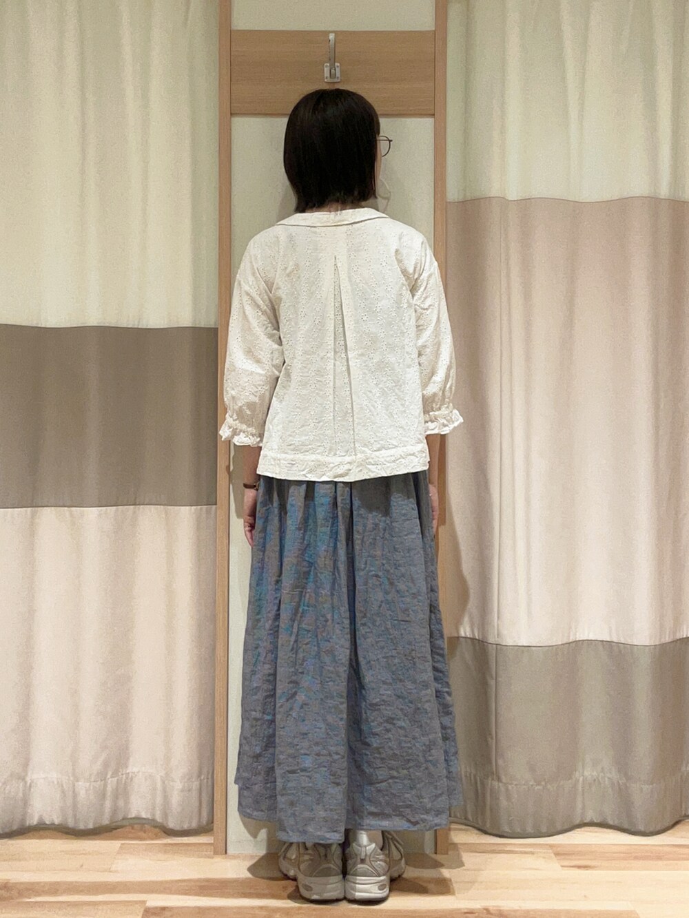 ホワイト系のノーカラージャケット、ブルー系のスカートを着用したレディースの春コーディネートの3枚目の写真