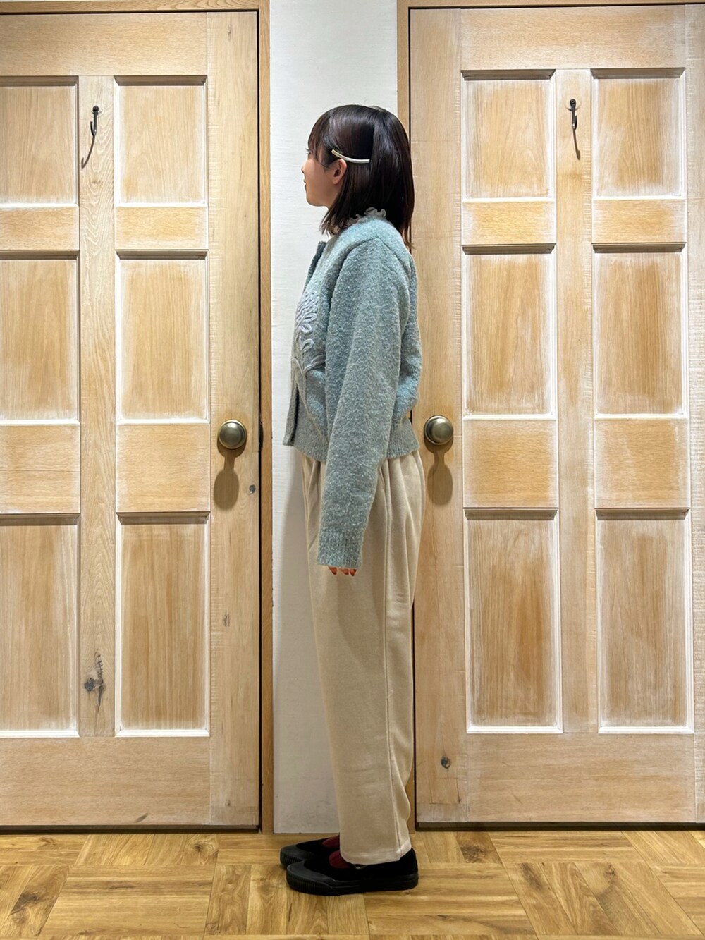 ブルー系のカーディガン/ボレロ、ホワイト系のTシャツ/カットソー、ホワイト系のパンツを着用したレディースの冬コーディネートの2枚目の写真