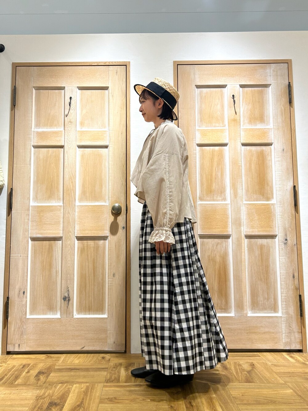 ベージュ系のカーディガン/ボレロ、ホワイト系のTシャツ/カットソー、ブラック系のスカートを着用したレディースの春コーディネートの2枚目の写真