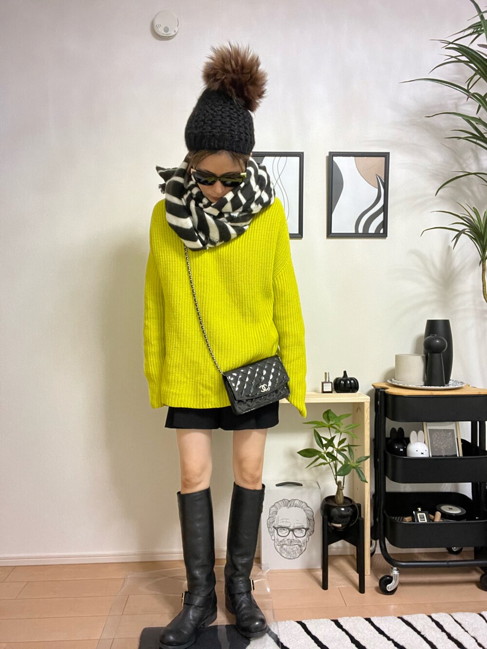 イエロー系のニット/セーター、ホワイト系のTシャツ/カットソー、ブラック系のパンツを着用したレディースの秋コーディネートの3枚目の写真