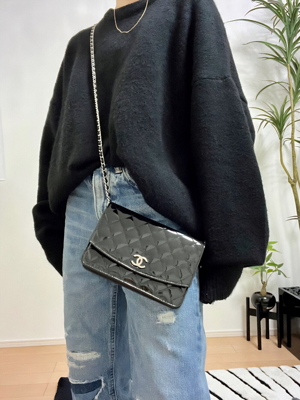 ブラック系のニット/セーター、ブルー系のデニムパンツ、ブラック系のサンダルを着用したレディースの秋コーディネートの5枚目の写真