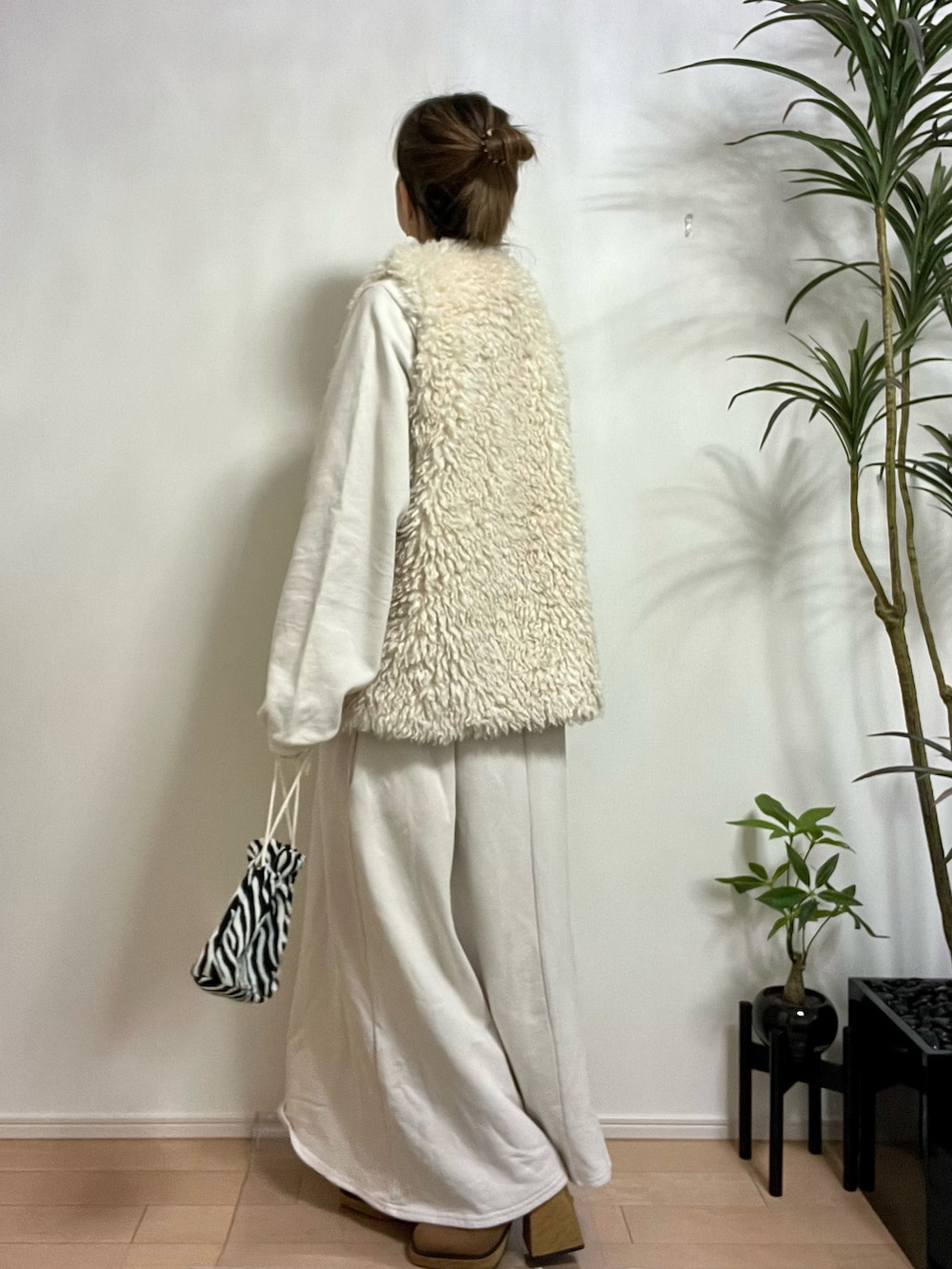 ホワイト系のベスト、ホワイト系のワンピース、ホワイト系のバッグを着用したレディースの秋コーディネートの2枚目の写真