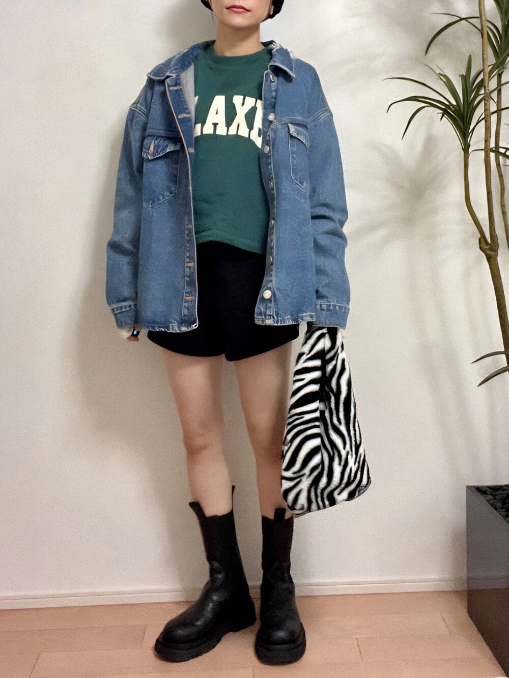 グリーン系のスウェット、ブルー系のデニムジャケット、ブラック系のパンツを着用したレディースの秋コーディネートの4枚目の写真