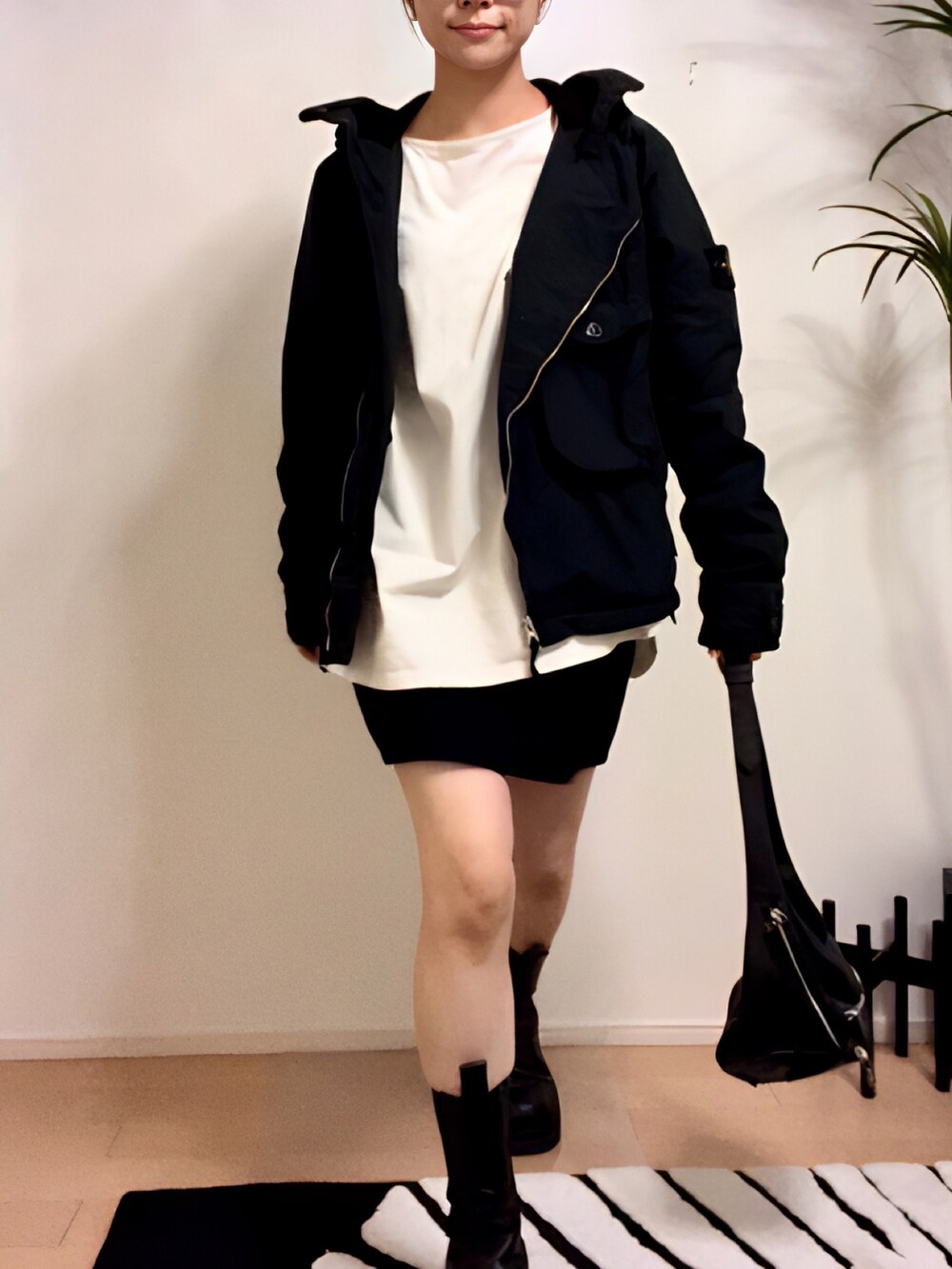 ホワイト系のTシャツ/カットソー、ブラック系のスカート、ブラック系のブーツを着用したレディースの秋コーディネートの3枚目の写真