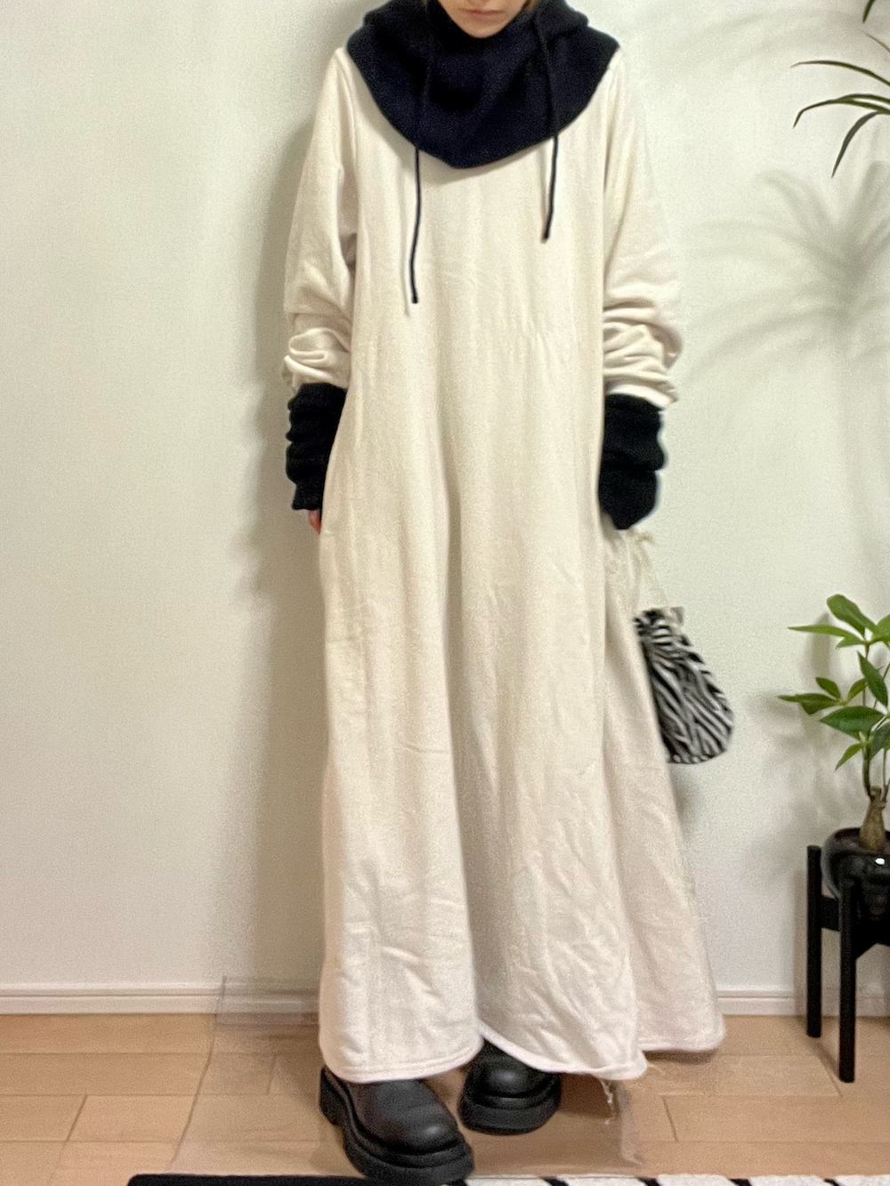 ホワイト系のワンピース、ホワイト系のバッグ、ブラック系のブーツを着用したレディースの秋コーディネートの3枚目の写真