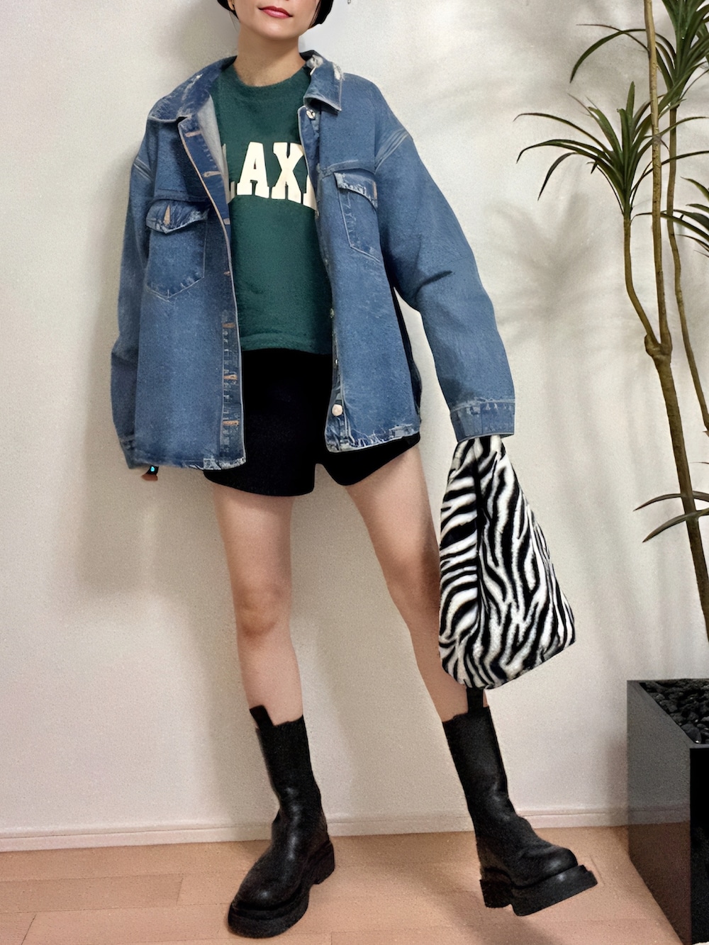 グリーン系のスウェット、ブルー系のデニムジャケット、ブラック系のパンツを着用したレディースの秋コーディネートの2枚目の写真