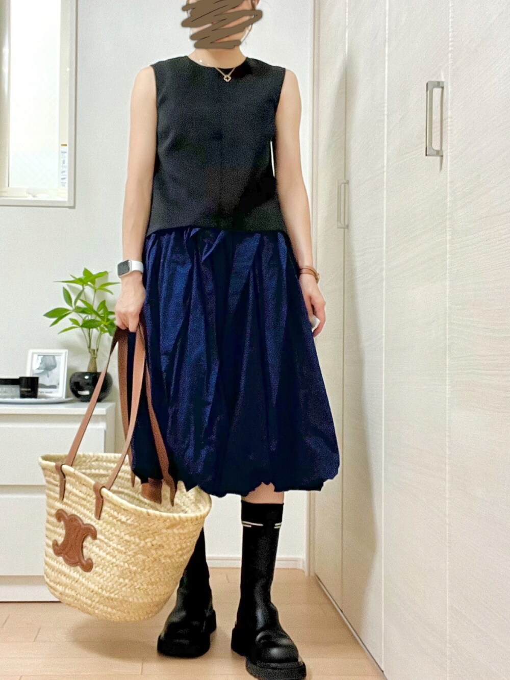 ブラック系のタンクトップ、ブルー系のスカート、ベージュ系のかごバッグを着用したレディースの夏コーディネートの2枚目の写真