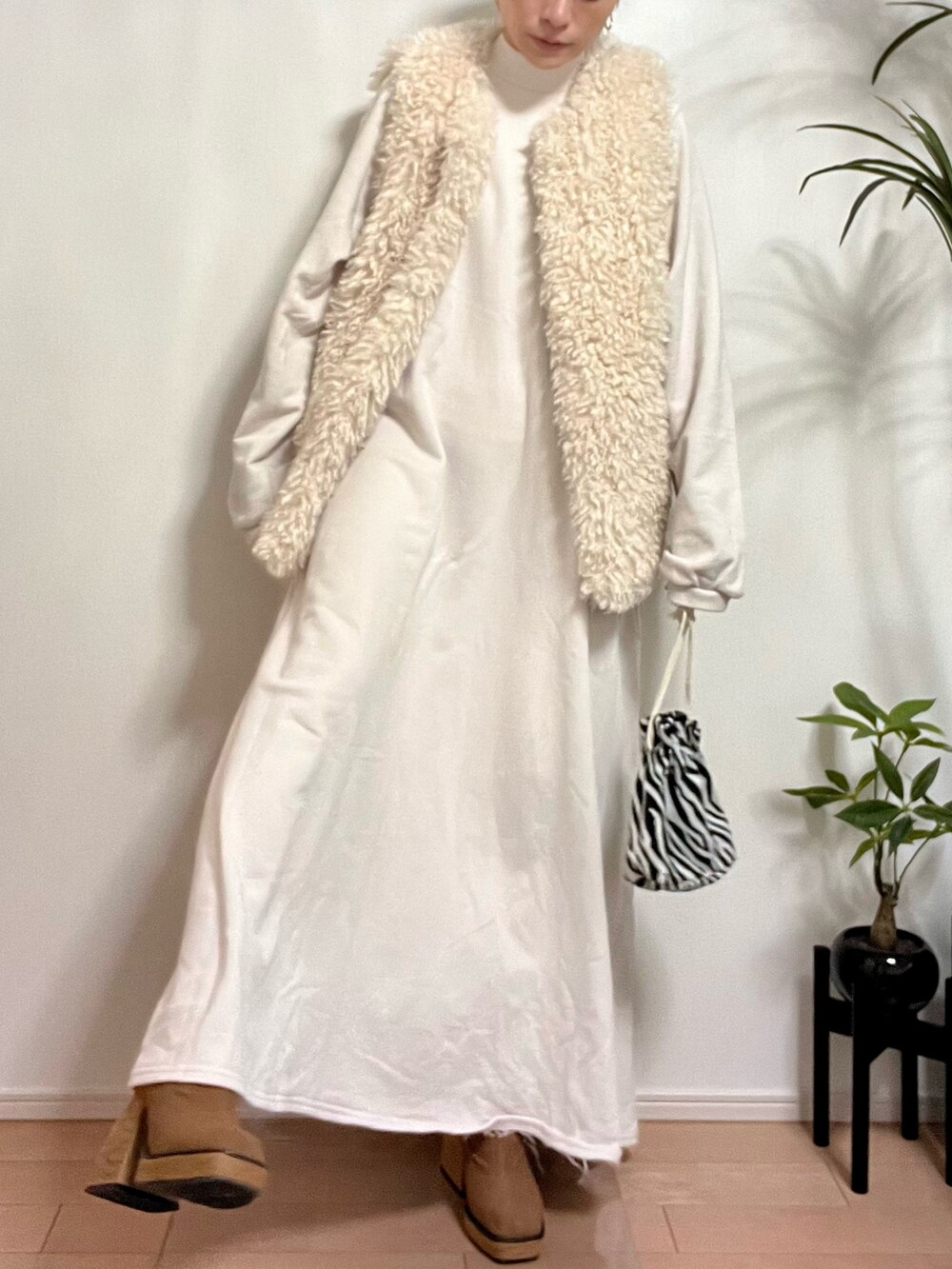 ホワイト系のベスト、ホワイト系のワンピース、ホワイト系のバッグを着用したレディースの秋コーディネートの3枚目の写真