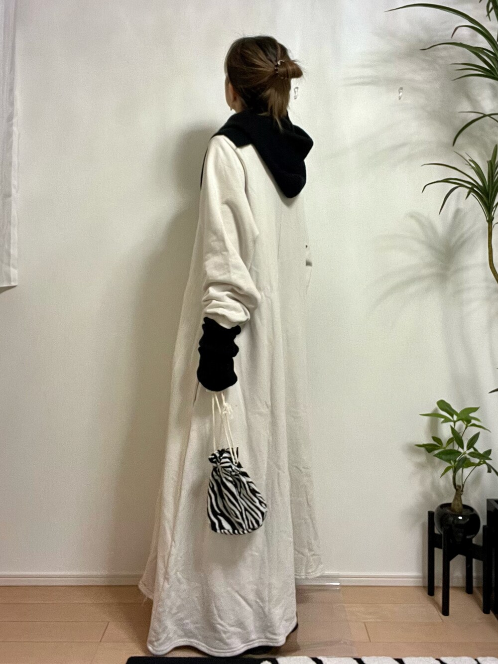 ホワイト系のワンピース、ホワイト系のバッグ、ブラック系のブーツを着用したレディースの秋コーディネートの2枚目の写真