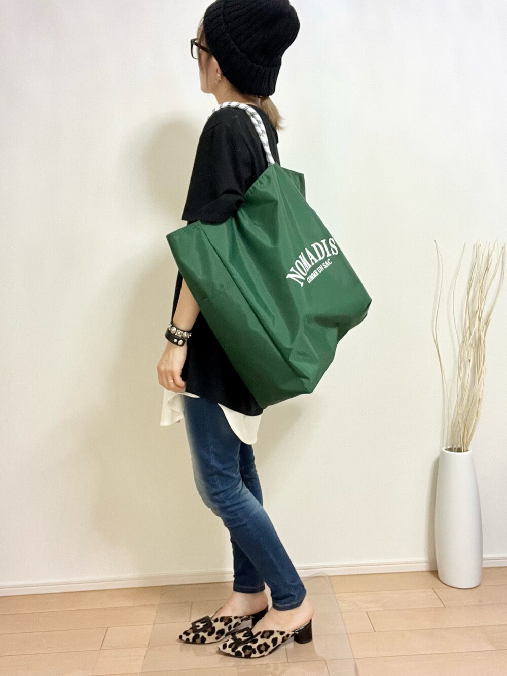 グリーン系のトートバッグ、ブラック系のTシャツ/カットソー、ホワイト系のキャミソールを着用したレディースの夏コーディネートの3枚目の写真