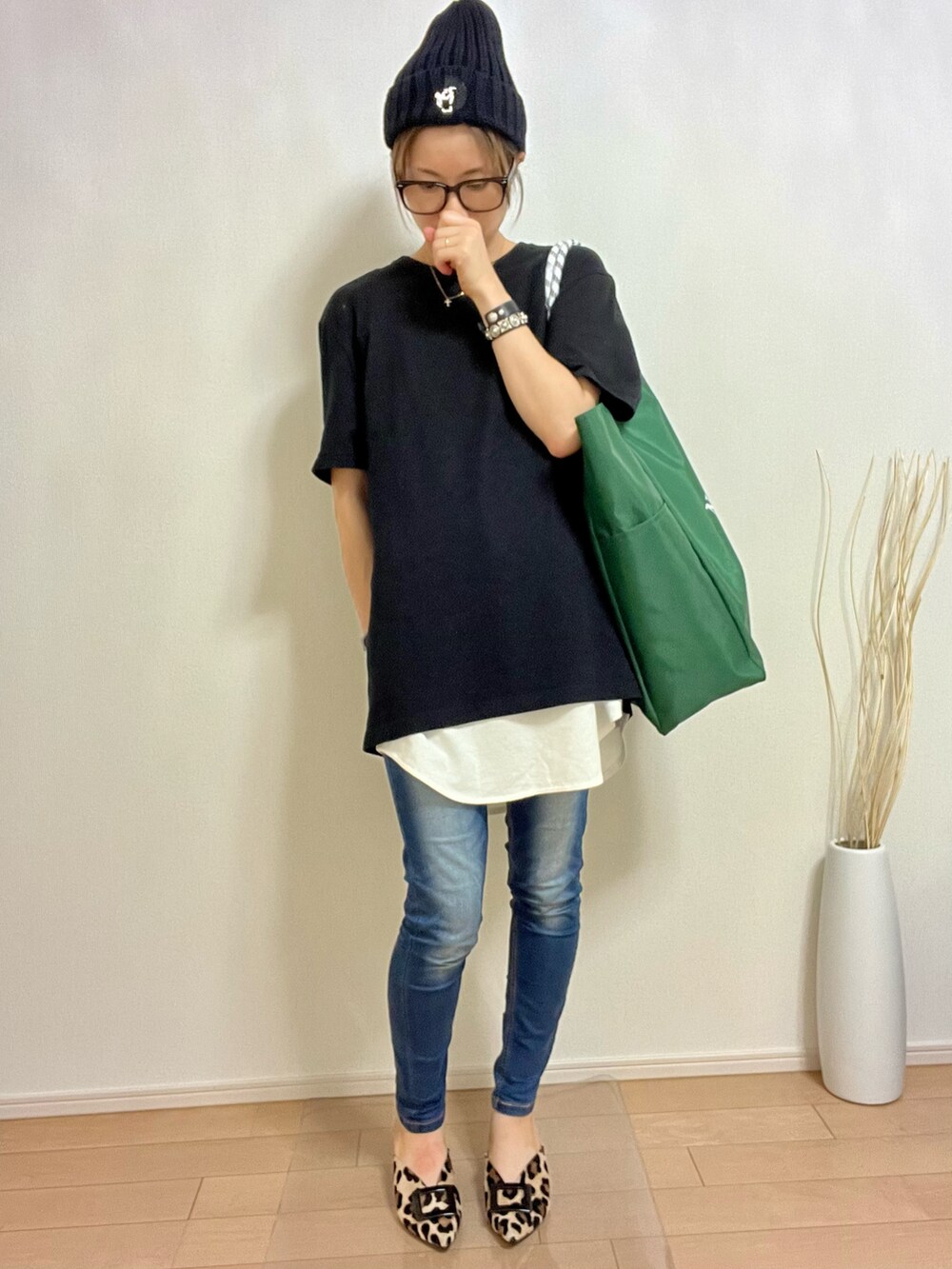 グリーン系のトートバッグ、ブラック系のTシャツ/カットソー、ホワイト系のキャミソールを着用したレディースの夏コーディネートの2枚目の写真