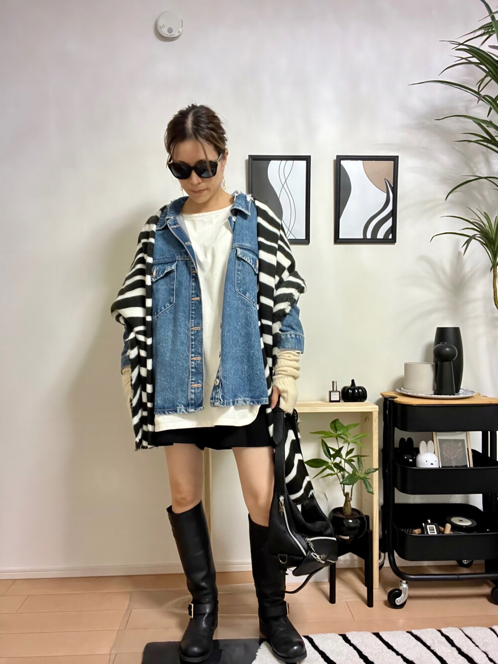 ブラック系のブーツ、ブルー系のデニムジャケット、ホワイト系のTシャツ/カットソーを着用したレディースの秋コーディネートの2枚目の写真