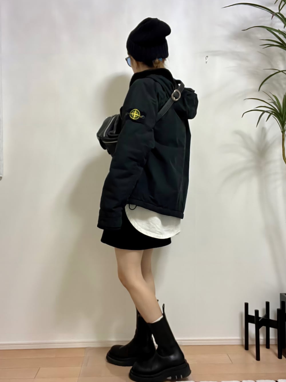 ホワイト系のTシャツ/カットソー、ブラック系のスカート、ブラック系のブーツを着用したレディースの秋コーディネートの2枚目の写真