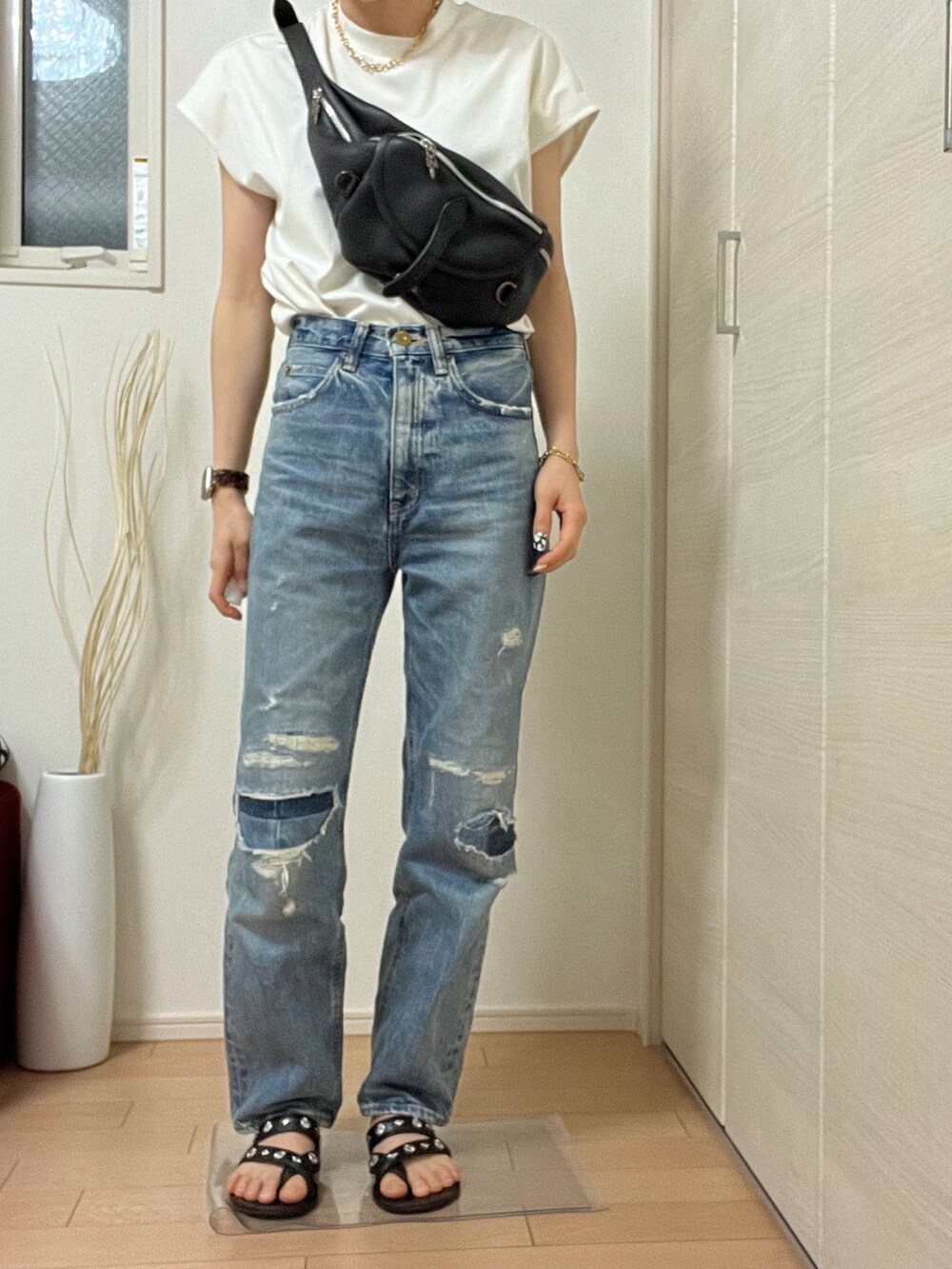 ホワイト系のTシャツ/カットソー、ブルー系のデニムパンツ、ブラック系のサンダルを着用したレディースの春コーディネートの2枚目の写真