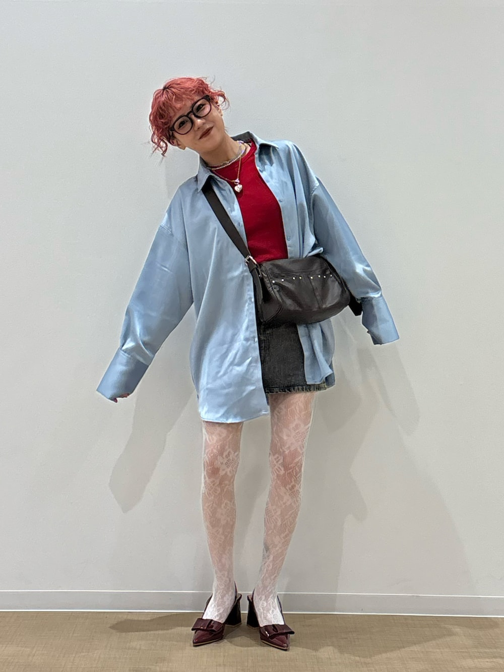 グレー系のデニムスカート、ブルー系のシャツ/ブラウス、ブラック系のショルダーバッグを着用したレディースの春コーディネートの2枚目の写真