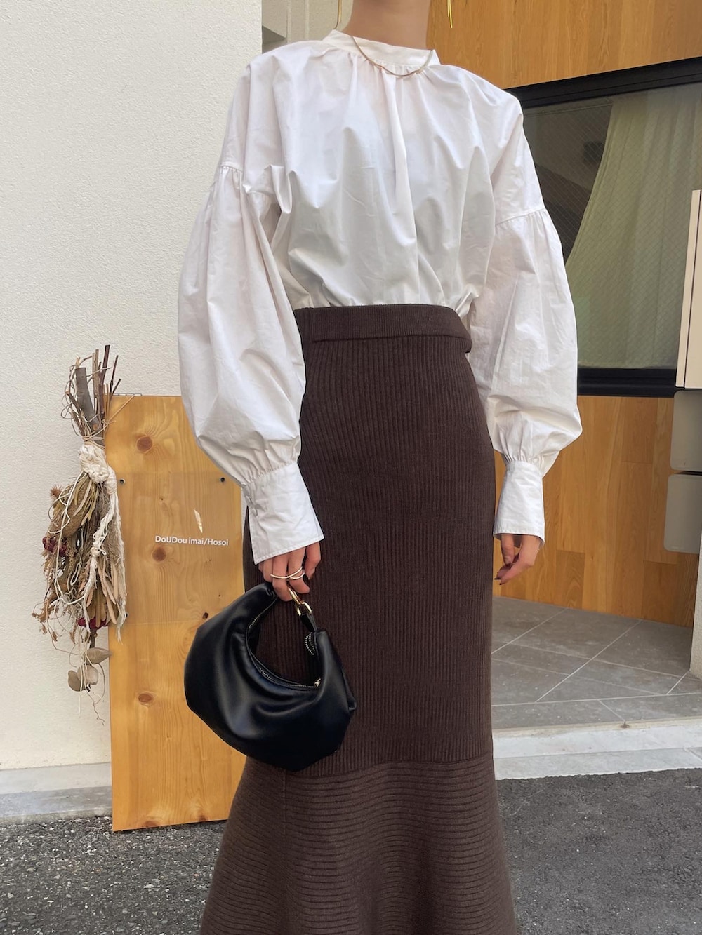 ベージュ系のローファー、ブラック系のショルダーバッグ、ブラウン系のスカートを着用したレディースの秋コーディネートの3枚目の写真