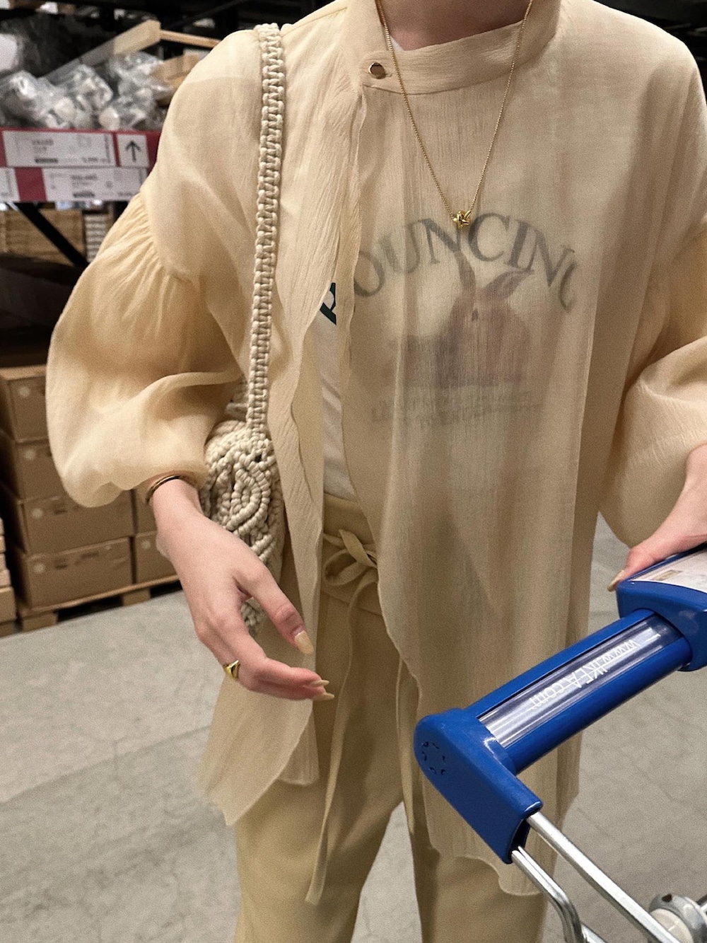 イエロー系のパンツ、ホワイト系のハンドバッグ、ベージュ系のシャツ/ブラウスを着用したレディースの春コーディネートの3枚目の写真