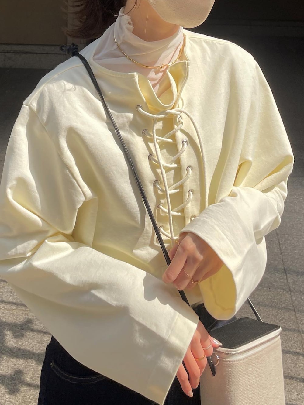 ホワイト系のTシャツ/カットソー、グレー系のショルダーバッグ、ブルー系のデニムパンツを着用したレディースの春コーディネートの3枚目の写真