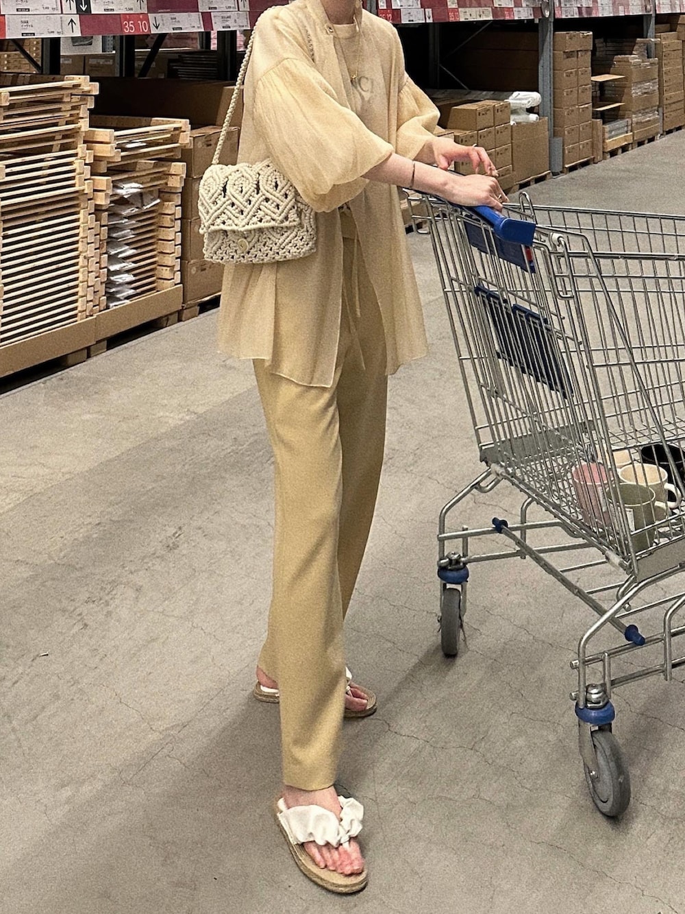 イエロー系のパンツ、ホワイト系のハンドバッグ、ベージュ系のシャツ/ブラウスを着用したレディースの春コーディネートの4枚目の写真