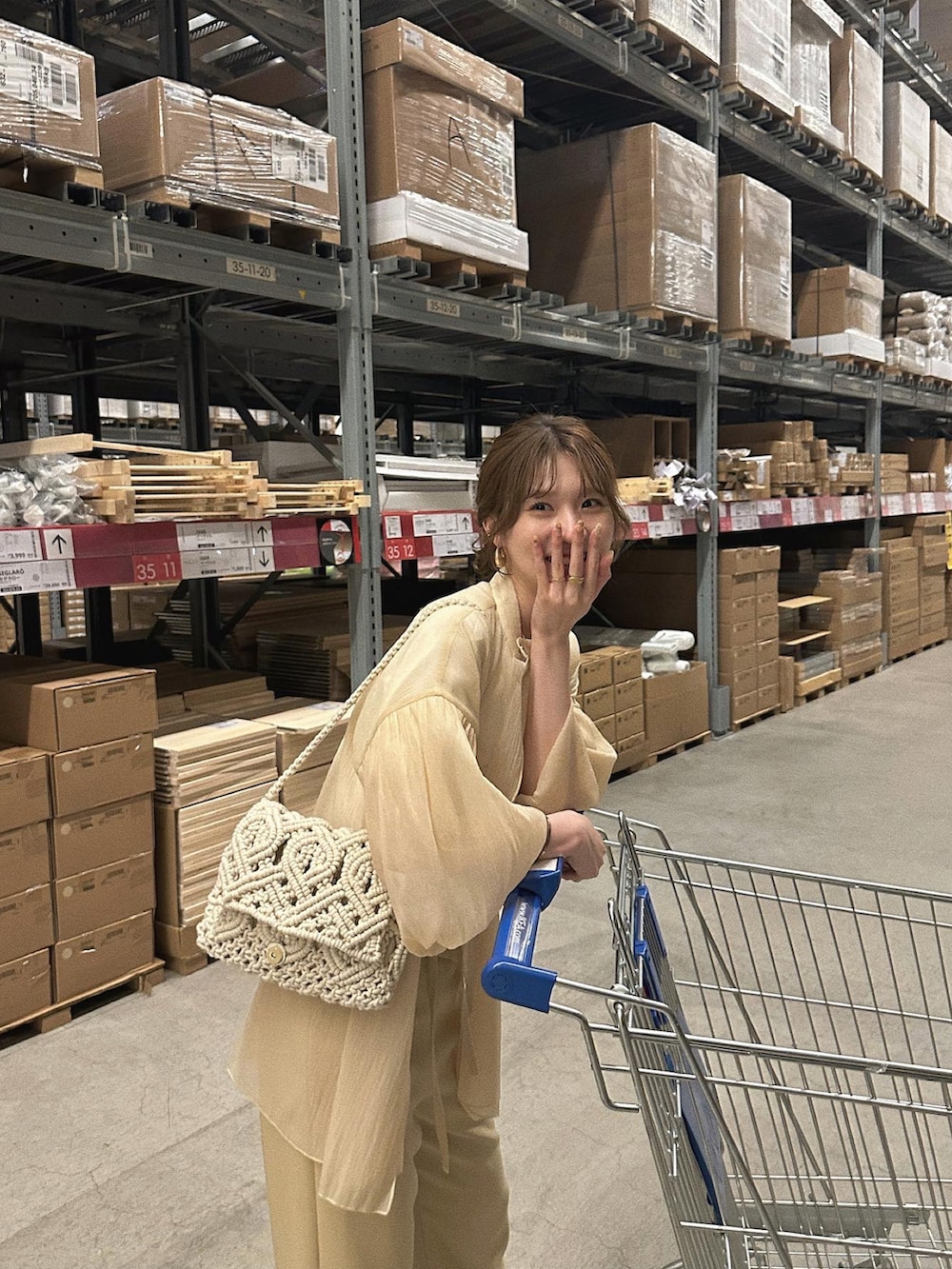 イエロー系のパンツ、ホワイト系のハンドバッグ、ベージュ系のシャツ/ブラウスを着用したレディースの春コーディネートの2枚目の写真