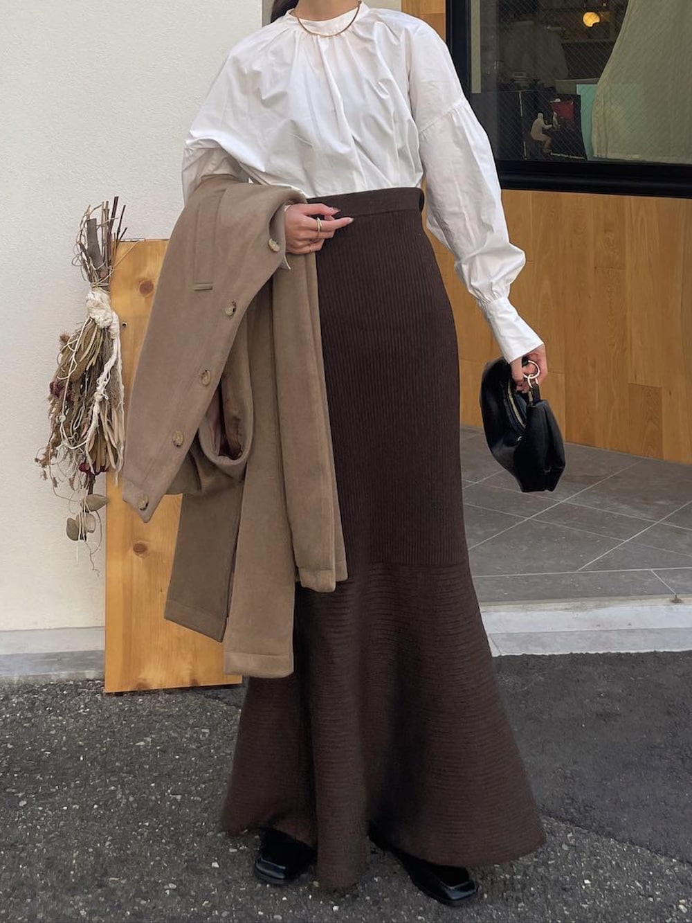 ベージュ系のローファー、ブラック系のショルダーバッグ、ブラウン系のスカートを着用したレディースの秋コーディネートの5枚目の写真