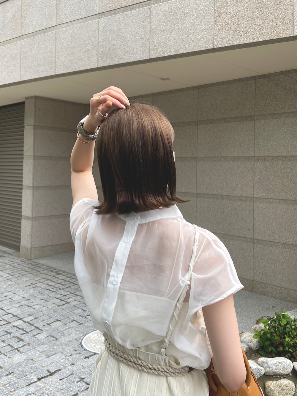 ベージュ系のワンピース、ホワイト系のシャツ/ブラウス、ベージュ系のベルトを着用したレディースの夏コーディネートの2枚目の写真