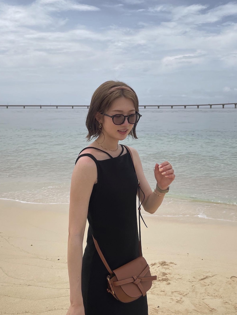 ブラック系のサンダル、ブラック系のワンピース、ブラウン系のショルダーバッグを着用したレディースの夏コーディネートの3枚目の写真