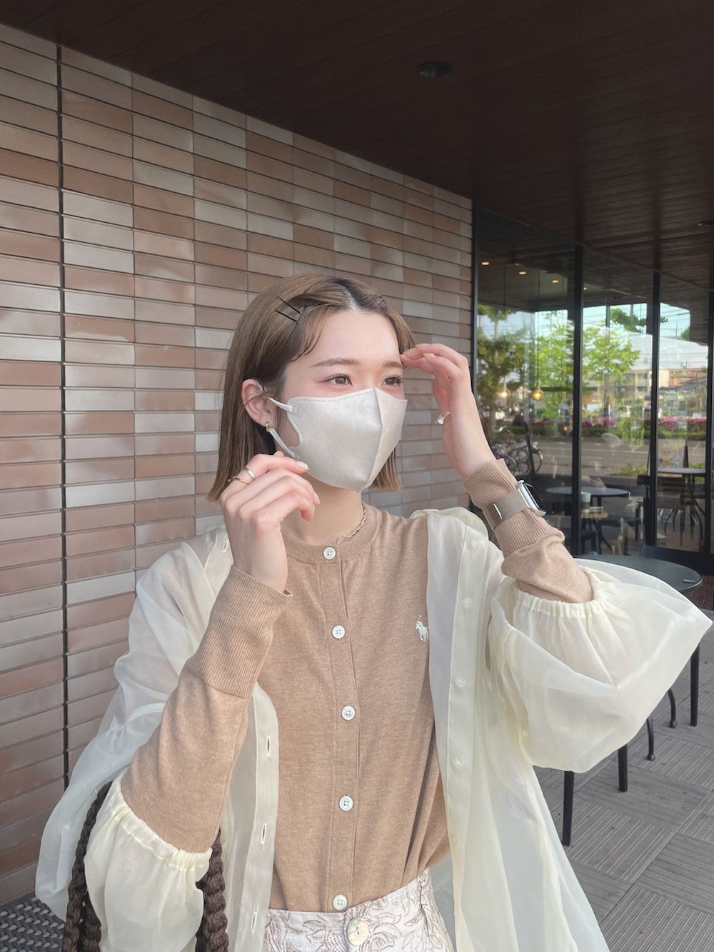 ブラウン系のカーディガン/ボレロ、ホワイト系のスラックス、ホワイト系のシャツ/ブラウスを着用したレディースの春コーディネートの2枚目の写真