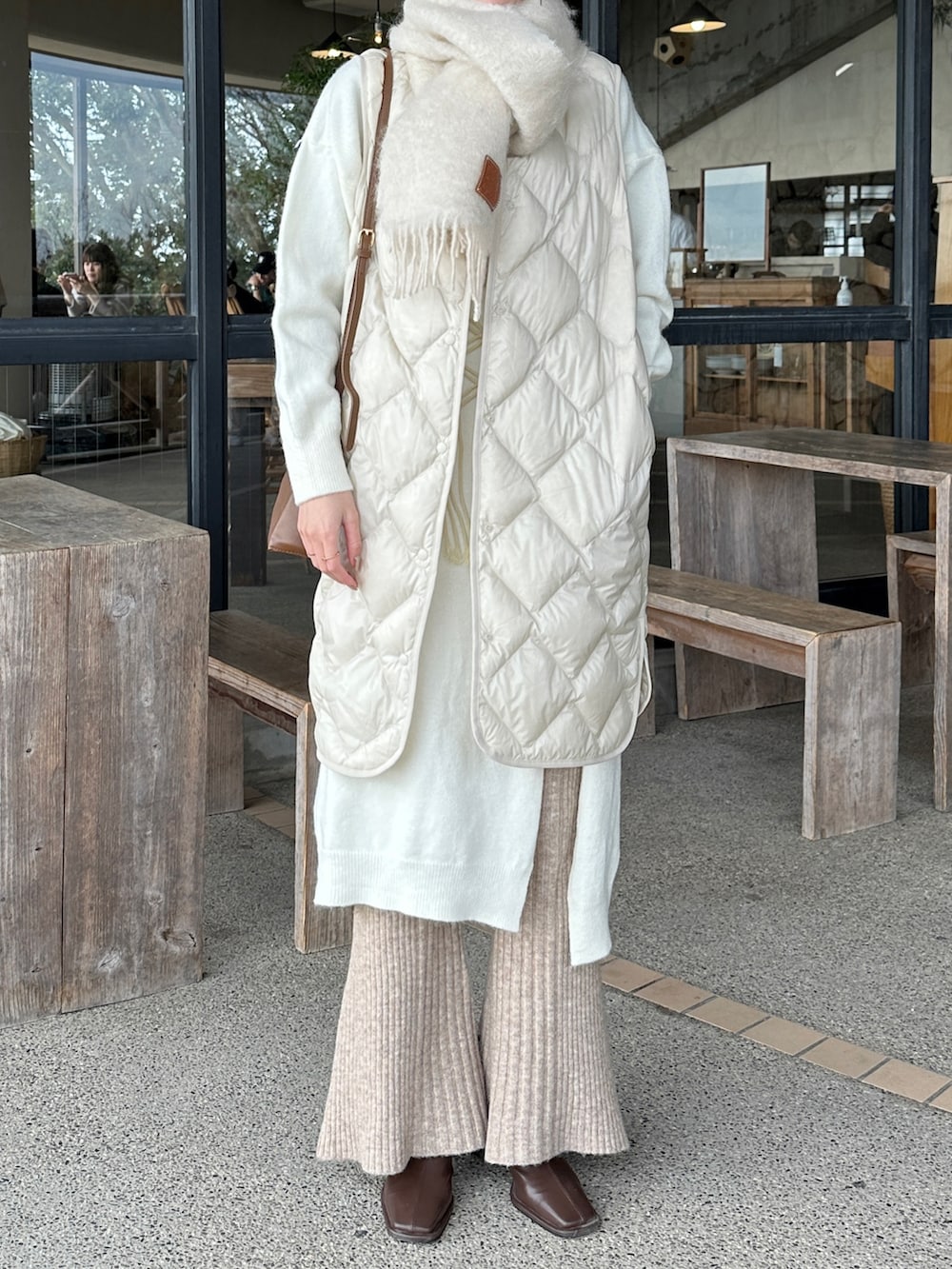 ホワイト系のジャケット/アウター、ベージュ系のパンツ、ブラック系のブーツを着用したレディースの冬コーディネートの2枚目の写真