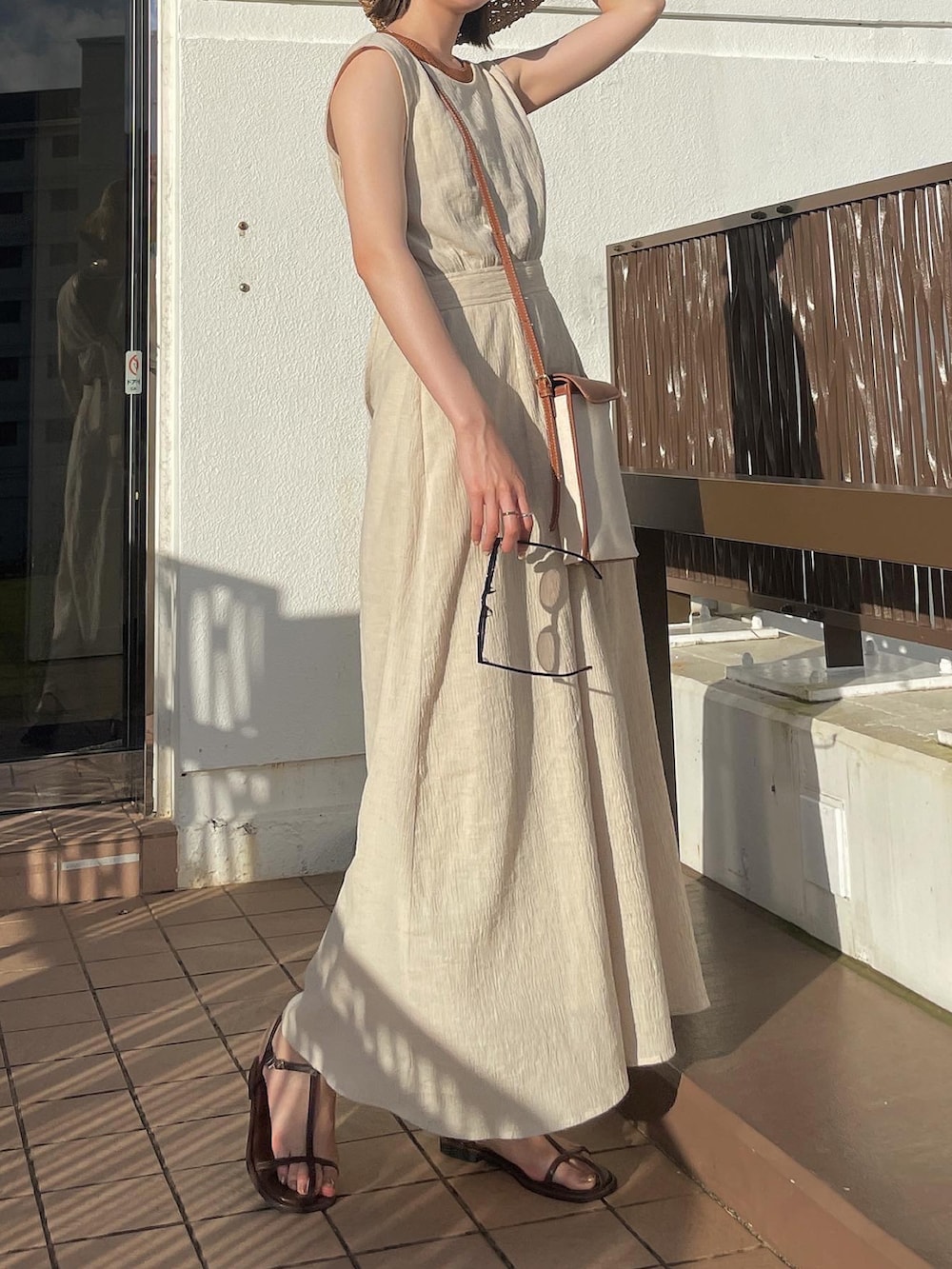 ホワイト系のワンピース、ブラウン系のタンクトップ、ブラウン系のサンダルを着用したレディースの夏コーディネートの2枚目の写真