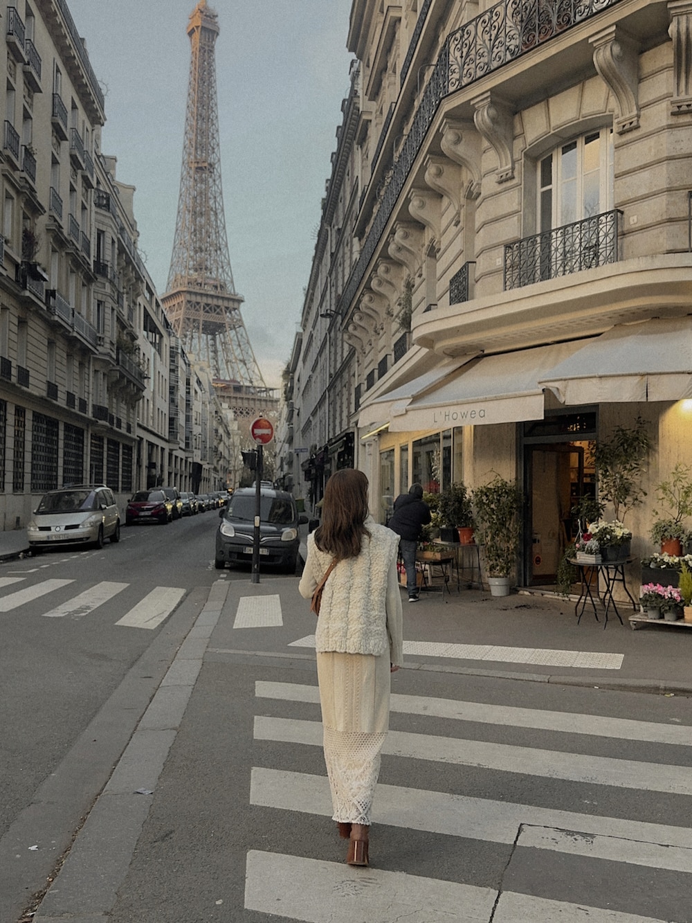 ホワイト系のニット/セーター、ブラウン系のバッグ、ブラウン系のブーツを着用したレディースの冬コーディネートの3枚目の写真